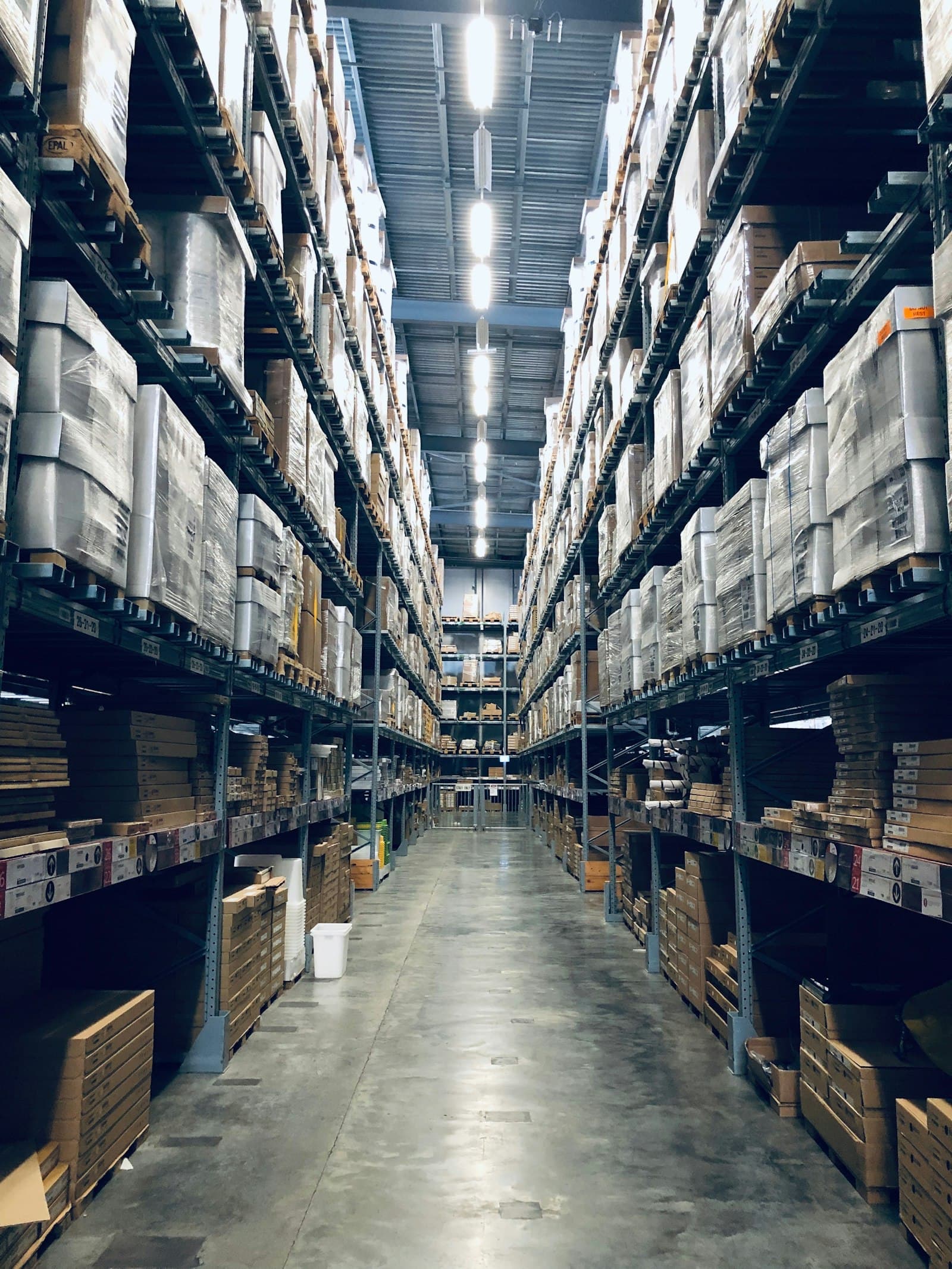 Rows of stocked warehouse shelving stretching into the distance